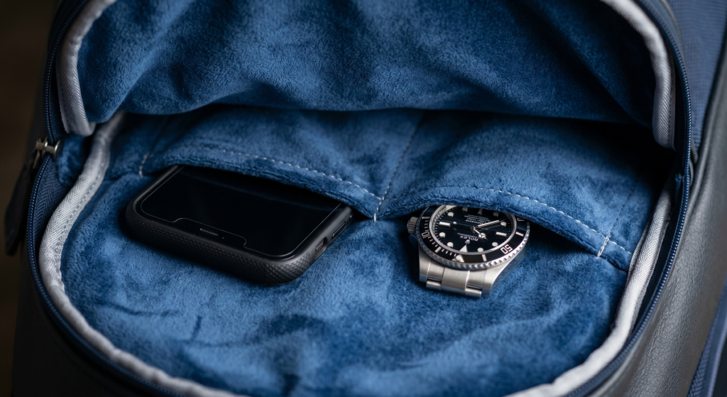 Interior view of a protective valuables pocket in a golf bag, lined with plush blue micro-velour to protect a phone and watch from scratches.